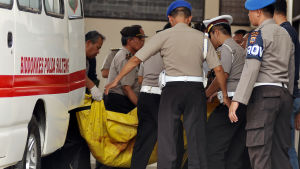 Polisen i Indonesien bär ut två kroppar ur ambulansen, båda är två döda medlemmar ur terrorgruppen East Indonesia Mujahidin (MIT)