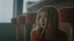 Edith Haagenrud-Sande imponerar i rollen som dottern Julia. Närbild på Julia (Edith Haagenrud-Sande) som har fått sår i ansiktet av glassplitter och sitter på golvet och ser rädd ut.