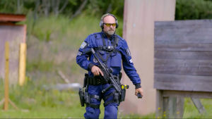 Inga skarpa lägen. Polisen Timo jobbar mycket med hundar, men här ser vi honom på skjutbanan. Polisen Timo promenerar över en skjutbana i full mundering.