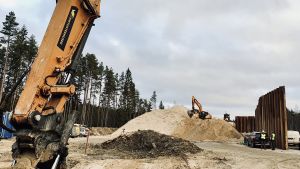 Sandhögen som utgör grunden för den upphöjda vägviadukten blir högre och högre. Ett par grävskopor på en järnvägsbyggplats i Saku utanför Tallinn.