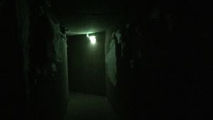 Tunnlarna är mörka och ogästvänliga. En svart tunnel med ett svagt grönt sken längst bort.