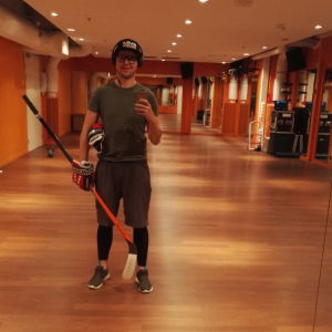 Robson tränar hand-öga-koordination på gymmet. Robson Lindberg i en gymnastiksal där han håller i en hockeyklubba.