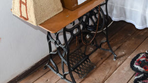 En gammal trampsymaskin med maskinen i en kupa på bordet.