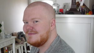Tobias Sjöman har fått sitt röda skägg tillbaka. Bild på Tobias Sjöman. I bakgrunden hallskåp och stolar i ett egnahem.