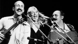 Peter, Paul and Mary kertoo legendaarisesta 1960-luvun folk-bändistä. Kaksi miestä ja nainen keskellä soittavat ja laulavat riehakkaan näköisesti.