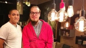 Tobias och Oscar om ensamhet Två män ser i kameran, lampor hänger i taket