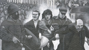 Händelserna under Bloody Sunday är förevigade på en husvägg i Derry. En man framför en politisk väggmålning i Derry.