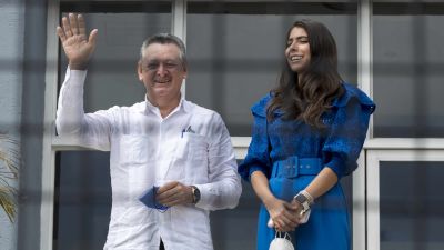 Oscar Sobalvarro vinkar till kameran. Bredvid honom står Berenice Quezada som ler och tittar åt sidan.
