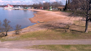 Utsikt från gamla bastun över Stallörsparken och Knipans strand. Sandstrand i en stad, i bakgrunden en sommarrestaurang på havet och andra byggnad.