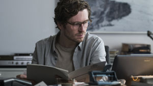 Tidskrift i blåsväder? Mikael Blomkvist (Sverrir Gudnason) saknar Lisbeth och ett nytt scoop. Sverrir Gudnasons Mikael Blomqvist lutad över sitt arbetsbord.