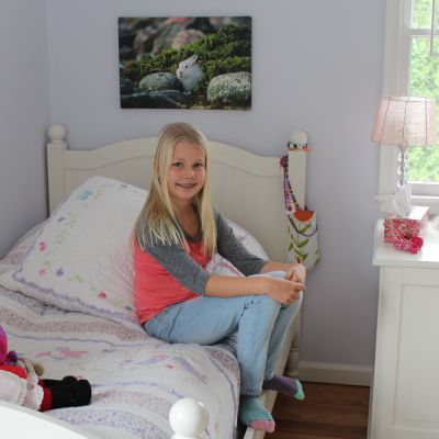Lia Hartwall sitter på sängen i sitt rum i USA