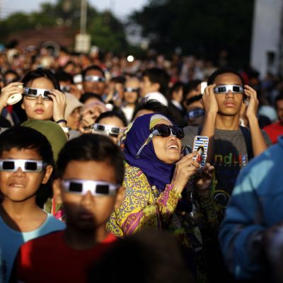 Ihmisiä auringonpimennyksen aikaan Indonesian pääkaupungissa Jakartassa.