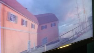 Åstranden i Åbo år 1812. En animerad bild av Åbo med orangea byggnader vid åstranden i Åbo och ett förtöjt segelfartyg.