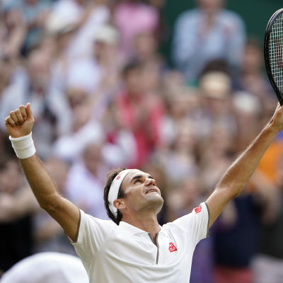 Roger Federer lyfter händerna upp mot skyn.