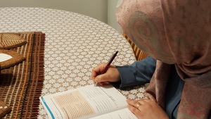 Iman pluggar för nästa språkprov. Iman Khaleel sitter med lärobok och studerar vid matbordet