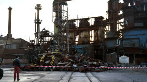 FN-steels gamla stålverk i Koverhar håller på att rivas. En person står och tittar på en hög med bråte framför en gammal stålfabrik.