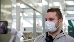 VAMK-studeranden Jonne Mattila siktar på att söka jobb på batterimaterialfabriken som ska byggas i Vasa. Studerande med grå huvtröja och munskydd.