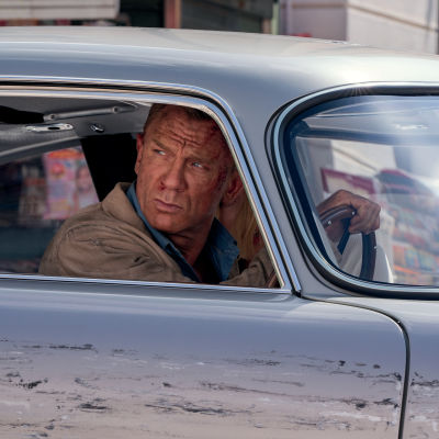 Närbild på James Bond (Daniel Craig) som kör bil och ser bekymrad ut.