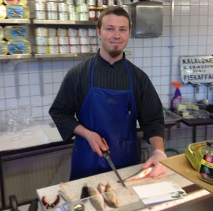 En del kunder köper fisken i hallen och röker den sedan hemma själva, säger fiskförsäljare Juho Keijonen. Fiskförsäljare Juho Keijonen i Sandvikens saluhall i Helsingfors