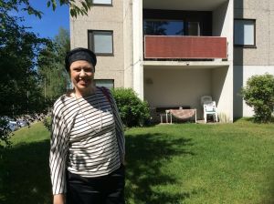 Maarit Feldt-Ranta utanför sitt barndomshem i Tallmo. Maarit Feldt-Ranta står leende utanför sitt hemhus i Tallmo i Karis.