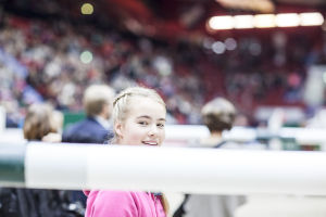 tyttö esteratsastuspuomin takana