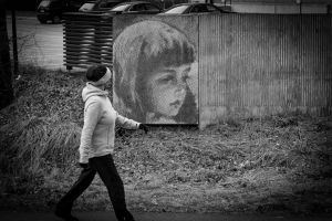 kvinna passerar mural föreställande barn