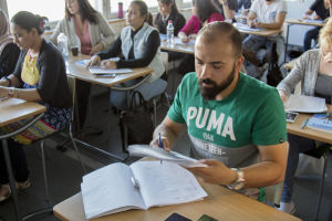 Ali har svårt att koncentrera sig på studierna i finska då han hela tiden tänker på sin familj. Ali studerar finska.
