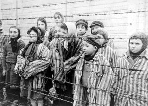 Auschwitzista vapautettuja juutalaislapsia vuonna 1945. Auschwitzista vapautettuja lapsia piikkilangan takana.