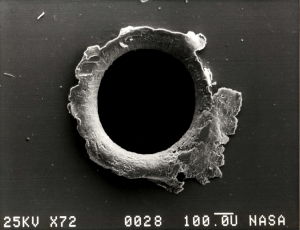 Ett hål i en satellit som träffats av en 100 mikrometers meteorit. Hål i satellit efter en träff av en mikrometeorit.