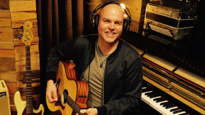 man med gitarr i musikstudio
