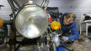 15-åriga Hemi Suvijärvi reparerar en moped i mopedverkstaden i Huutjärvi. Verkstaden får inte längre stöd av kommunen.
