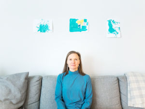 Petriikka Pohjanheimo istuu sohvalla ja katsoo kohti kameraa.