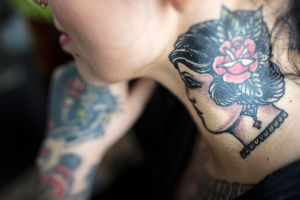 Lähikuva Natalia Tolmatsovan kaulalle tatuoidusta naishahmosta.