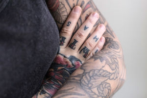 Lähikuva Natalia Tolmatsovan tatuoiduista käsivarsista.