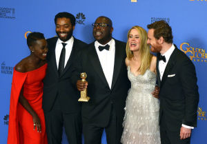 Golden Globe 2014: 12 Years a Slave -elokuvan brittiohjaaja Steve McQueen poseeraa keskellä Kultaisen maapallon kanssa. // Kuva: EPA / Paul Buck