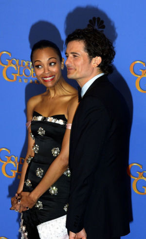 Golden Globe 2014: 12 Years a Slave -elokuvan brittiohjaaja Steve McQueen poseeraa keskellä Kultaisen maapallon kanssa. // Kuva: EPA / Paul Buck