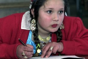 En romsk flicka följer med matematikundervisningen. En romsk flicka i skolan.