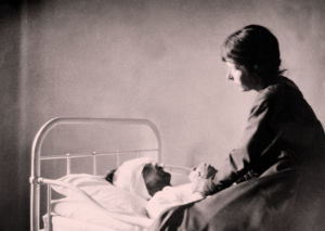 Alma Kuula miehensä Toivo Kuulan sairasvuoteen äärellä Viipurin lääninsairaalassa 1918.