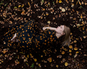 Autumn. Wilma Hurskaisen teos Autumn: nainen makaa maassa syksyn lehtien keskellä