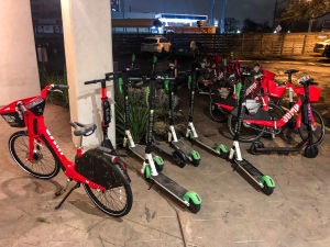 Olika färgade elektriska sparkcyklar står parkerade i Austin i Texas.