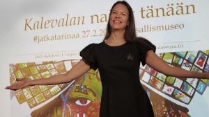Kirjailija Tiina Piilola levittää käsiään kuten Kalevalan Aino Suomen Kansallismuseossa.