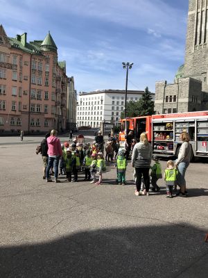 En grupp med barn och vuxna framför en brandbil.