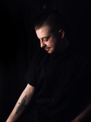 Hans tatuering finns på armen Pojke som tittar på sin tatuering som han har på armen.