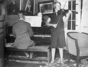 Anja ja Lassi harjoittelevat kotona. Anja Ignaitus soittaa viulua ja veli Lassi säestää 1920-luvun puolivälissä.