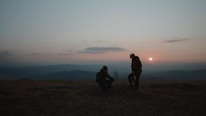 Maisema tunturin laelta Lapista, jossa kaksi siluettia auringonlaskua vasten. Tonislav Hristovin Veeran maaginen elämä -elokuvasta.