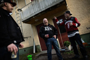 Tre killar står ute och röker.
