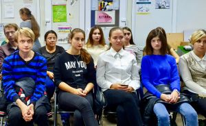 Svenska Yles medarbetare ställs plötsligt och överraskande inför en grupp frågvisa studenter och lokala medier. De flesta utländska journalister har inte tid att stanna i Pokrovsk på väg till fronten och krigszonen. Marina Derkatj med vit skjorta längst fram, Vladislav Bowman längst till vänster. Vladislav Bowman, Marina Derkatj, Jana, Daria och andra studenter på Donetsk nationella tekniska universitet i Pokrovsk lyssnar när Yles medarbetare svarar på deras frågor.