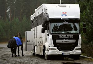 Ibland sätter sig storebror Daniel eller mamma Carita bakom ratten, men oftast är det John själv som kör hästbilen. Ryttaren John Antell med häst bredvid hästtransportbilen.