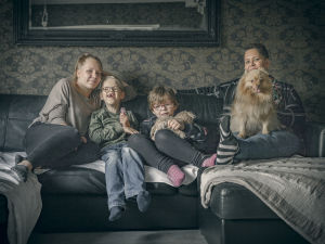 Familjen Jääskeläinen sitter i soffan.