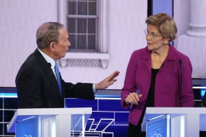 Elizabeth Warren och de andra medkandidaterna gick hårt åt Michael Bloomberg under hans första tv-debatt. En gråhårig man i kostym håller upp handen mot en blond kvinna i glasögon. Båda står bakom podier.